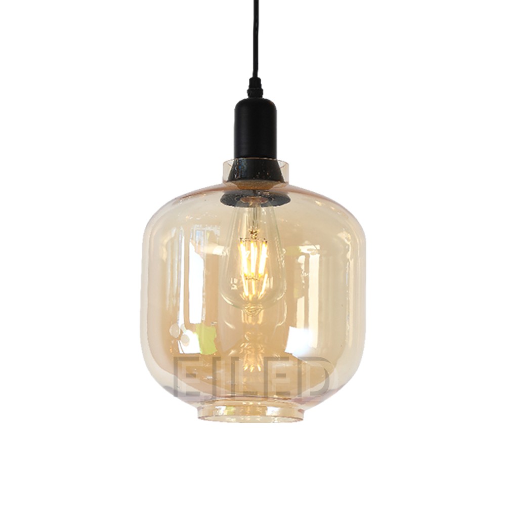 This amber tinted glass round pendant lamp features a visible vintage LED filament bulb inside an enclosed glass shade suspended by a black cord.