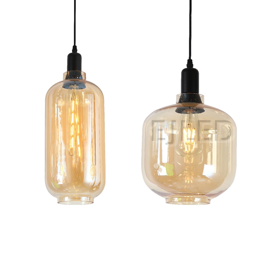 This amber tinted glass round pendant lamp features a visible vintage LED filament bulb inside an enclosed glass shade suspended by a black cord. - view 2