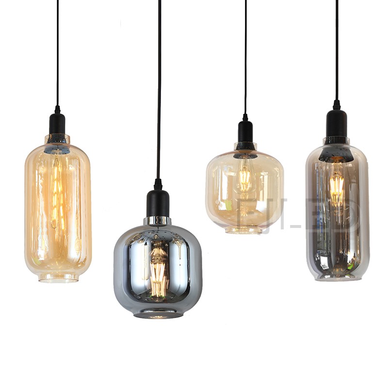 This amber tinted glass round pendant lamp features a visible vintage LED filament bulb inside an enclosed glass shade suspended by a black cord. - view 6