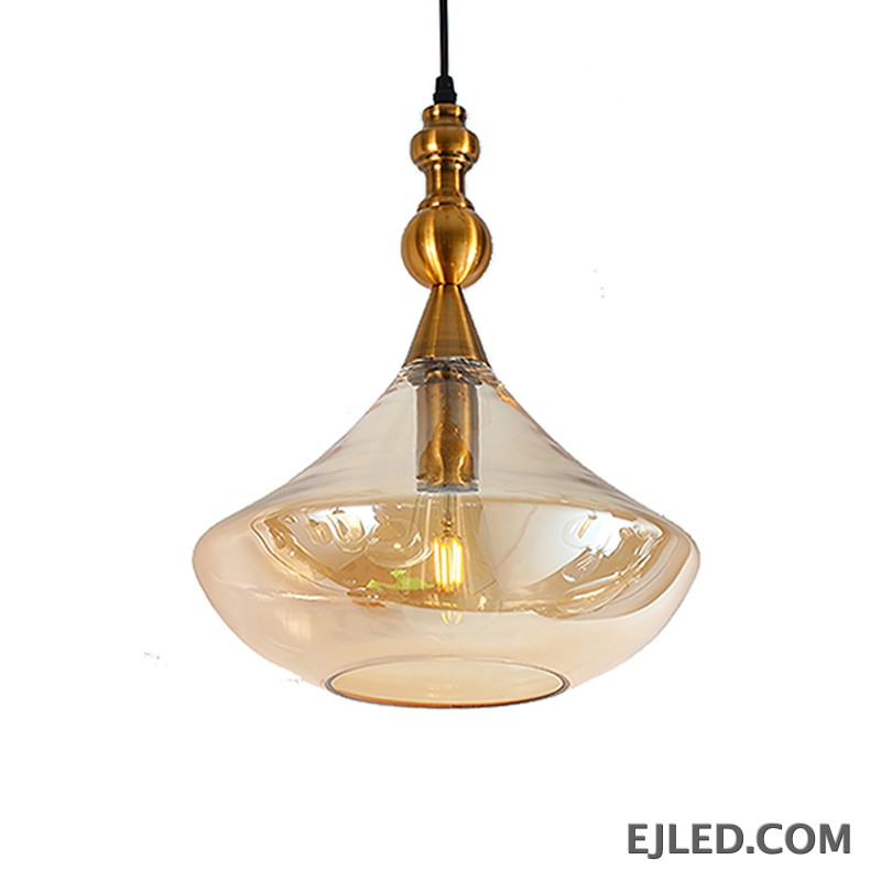 This glass bowl pendant light features a wide, shallow clear glass shade complemented by a brushed brass rim and ceiling canopy. It projects diffused, ambient light from a single lamp, hanging from a fabric-covered cord.