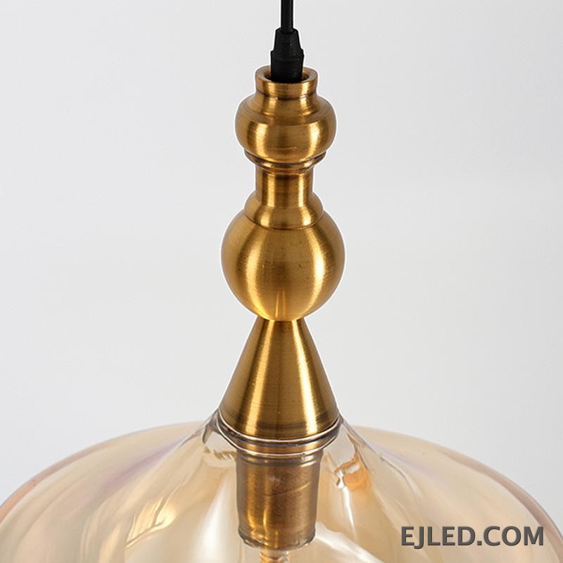This glass bowl pendant light features a wide, shallow clear glass shade complemented by a brushed brass rim and ceiling canopy. It projects diffused, ambient light from a single lamp, hanging from a fabric-covered cord. - view 5