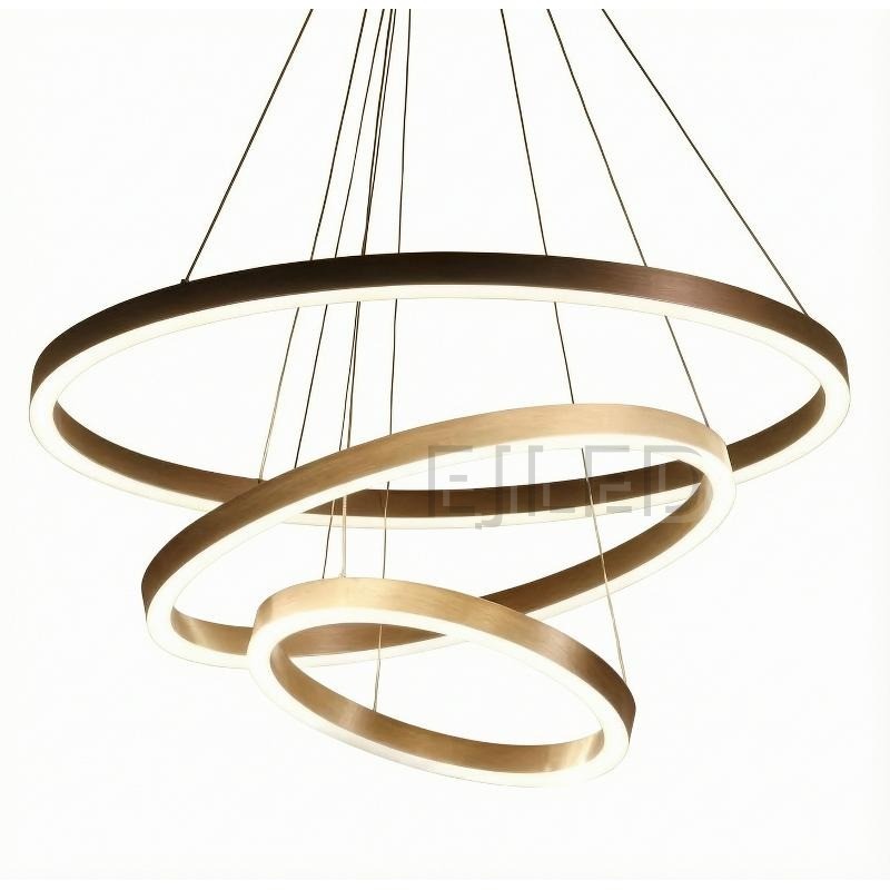 Three nested aluminum rings suspend at staggered angles from adjustable steel cables, combining brushed metallic finishes with continuous internal LED illumination.
