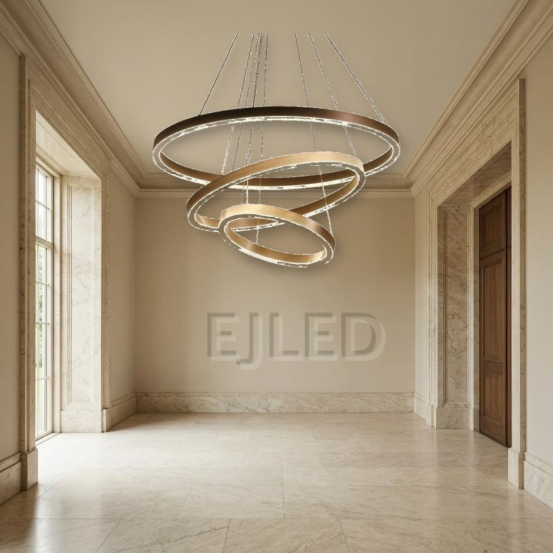 Three nested aluminum rings suspend at staggered angles from adjustable steel cables, combining brushed metallic finishes with continuous internal LED illumination. - view 4
