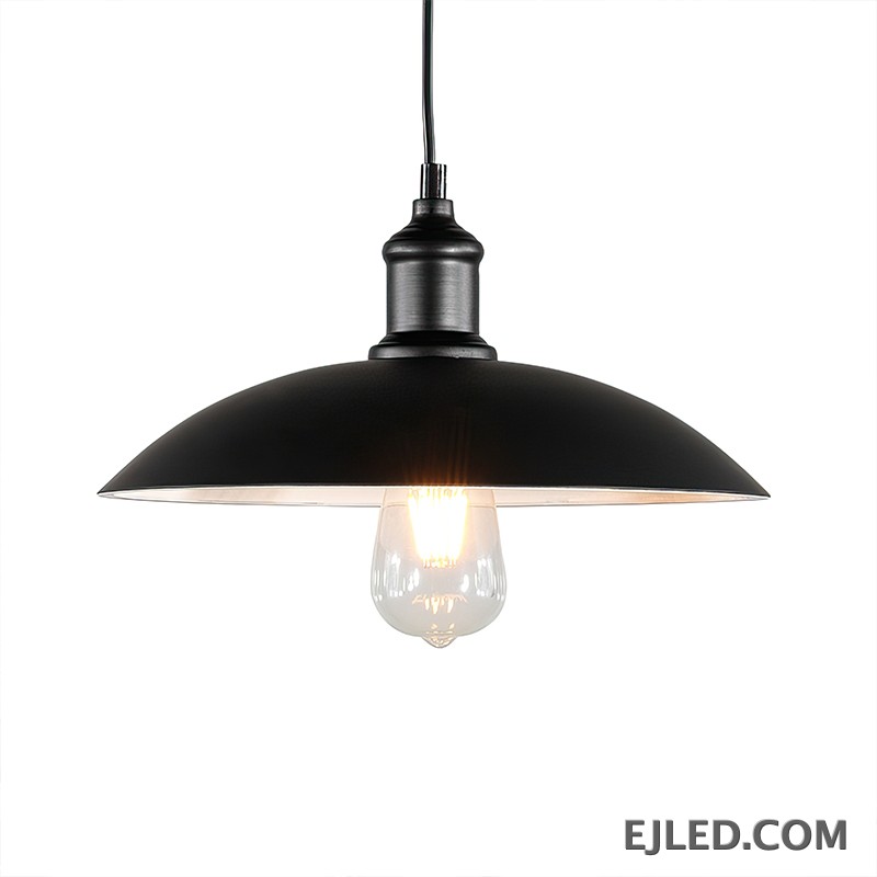 This iron dome pendant lamp features a matte black exterior shade and a reflective interior. It suspends from a black cord and illuminates with a single, exposed bulb. The fixture has a dark, textured finish on its connecting hardware.