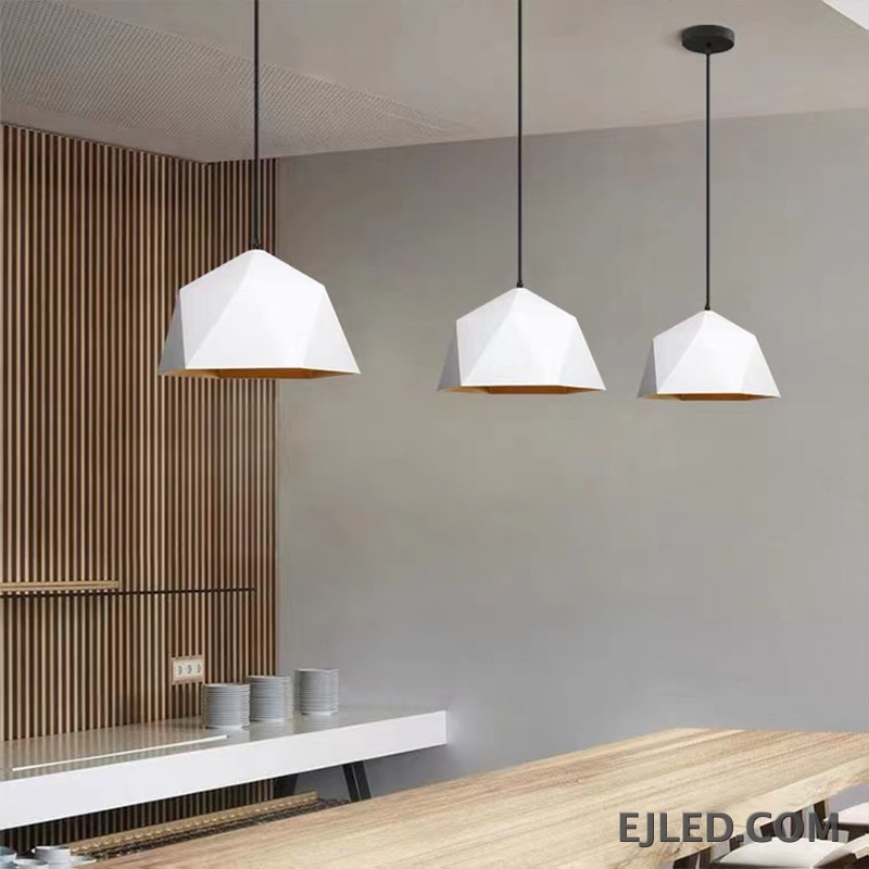 This steel pendant light features a multi-faceted geometric shade. It has a matte black exterior finish and a contrasting warm orange interior, providing downward illumination. - view 2