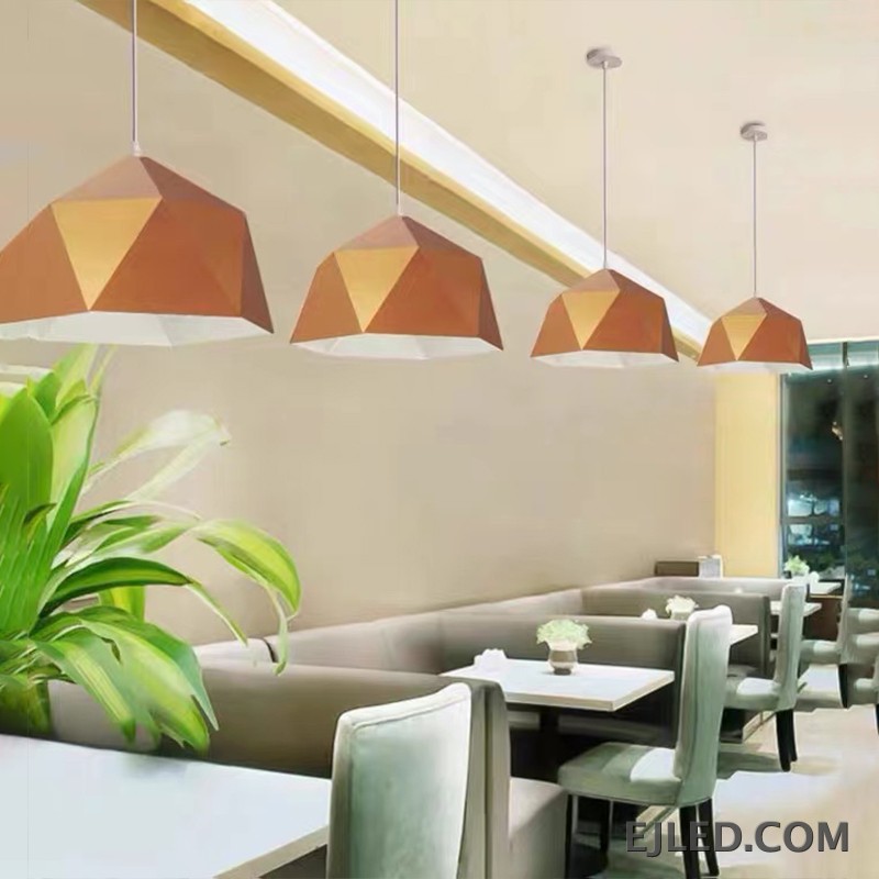 This steel pendant light features a multi-faceted geometric shade. It has a matte black exterior finish and a contrasting warm orange interior, providing downward illumination. - view 5