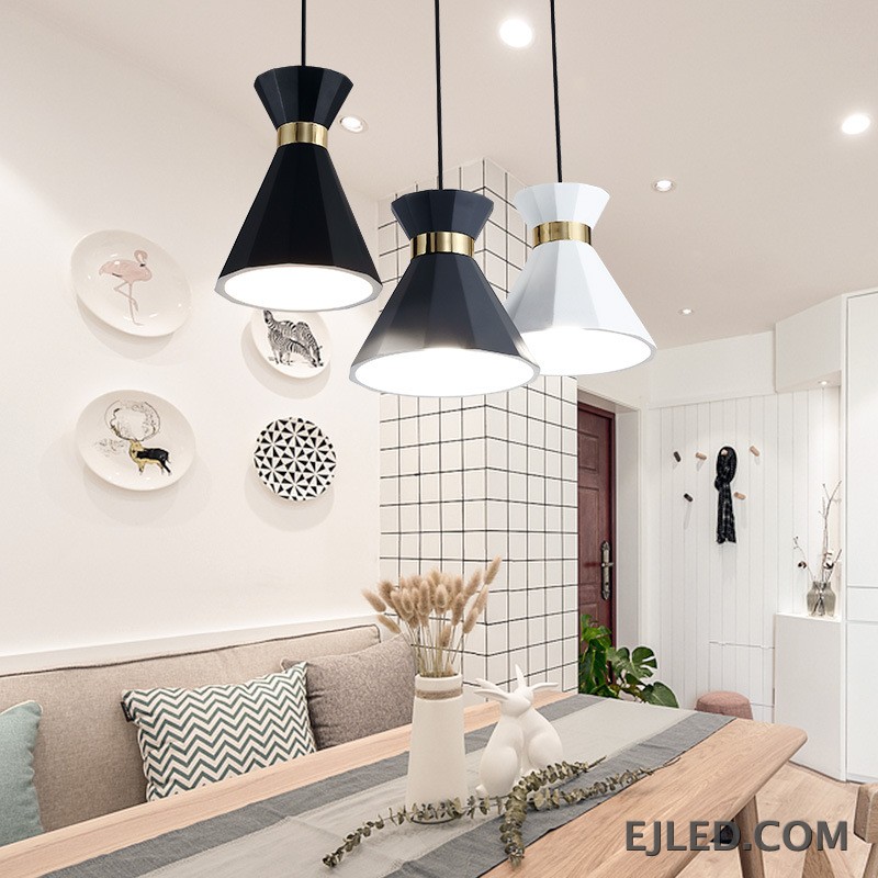 Esta luminaria incluye tres lámparas colgantes de aluminio facetado en negro, gris y blanco, cada una con una banda de color dorado. Cuelgan de una canaleta lineal negra y proporcionan luz directa hacia abajo a través de sus pantallas de cono abierto. - view 4