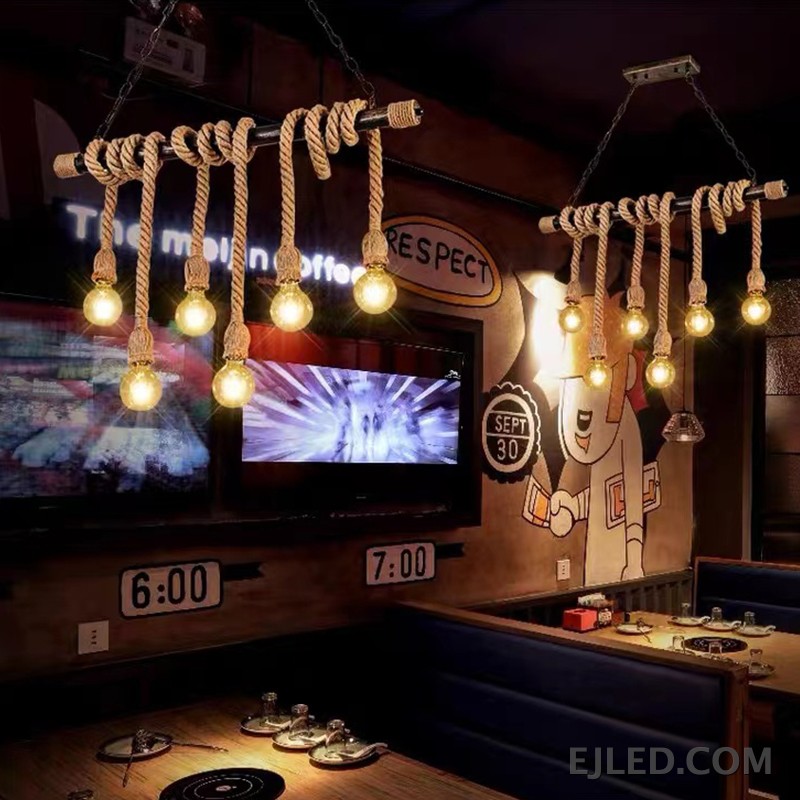 This six-light chandelier features a linear steel bar wrapped with natural hemp rope, suspending exposed bulbs. Two chains connect it to a rectangular ceiling plate, offering a distinctive, open aesthetic. - view 2