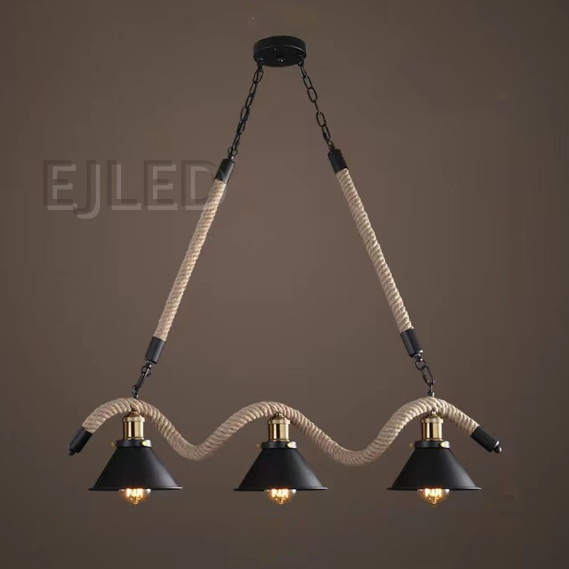 This three-light pendant features bell-shaped metal shades with a black finish, suspended along a wavy hemp rope. It hangs from a black ceiling plate via metal chains and straight ropes, offering a distinctive look. - view 2