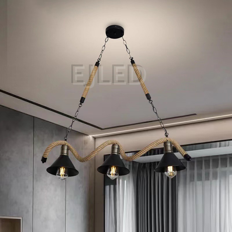 This three-light pendant features bell-shaped metal shades with a black finish, suspended along a wavy hemp rope. It hangs from a black ceiling plate via metal chains and straight ropes, offering a distinctive look. - view 6