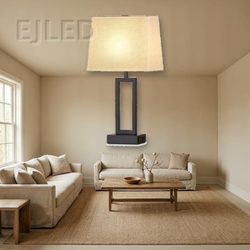 This modern table lamp features a dark metal rectangular base, an open geometric column, and a trapezoid fabric shade with built-in USB charging ports. - view 4