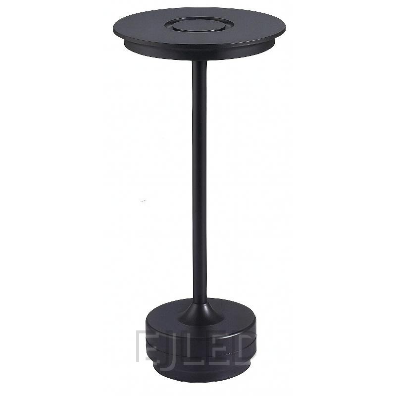 This black metal table lamp features a slim vertical stem connecting a flat circular top shade to a weighted round base. It provides portable cordless illumination.