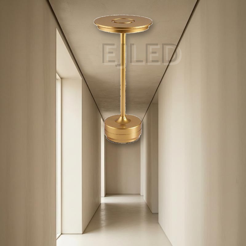 This minimalist metal table lamp features a solid round base, a slender vertical stem, and a flat circular top shade in a uniform gold finish. - view 4