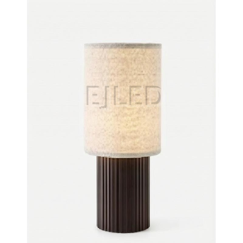 This table lamp features a cylindrical fabric shade paired with a fluted dark brown base, designed for hospitality and residential interior projects.