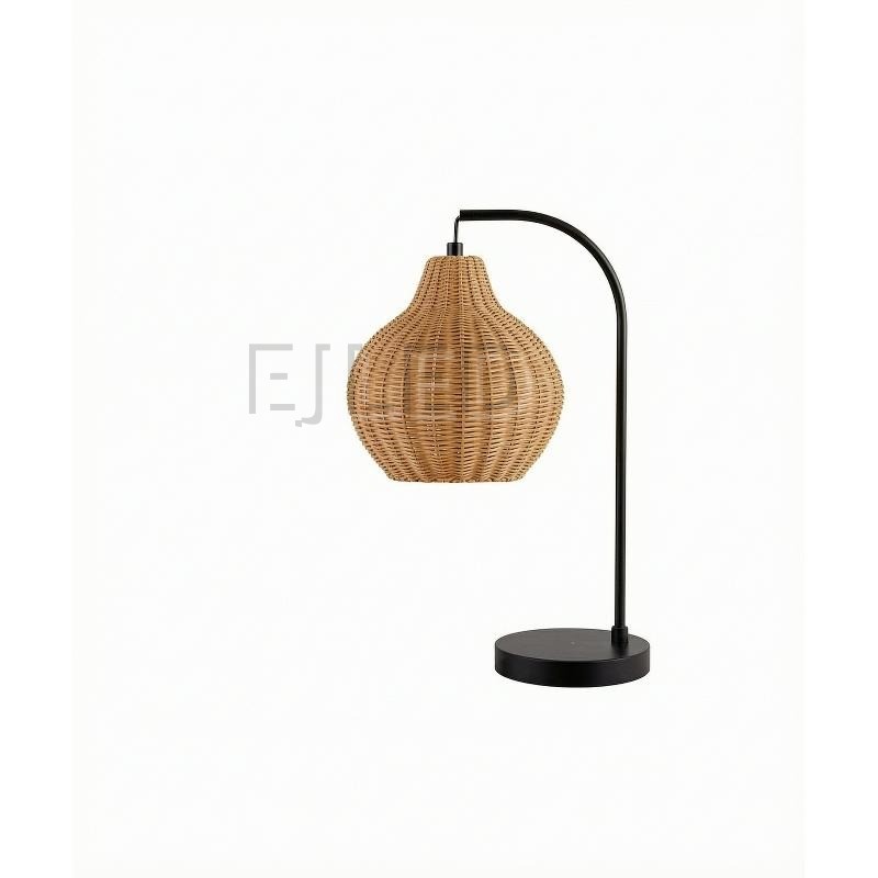 This table lamp features a curved black metal arm holding a woven rattan shade with an open bottom, mounted on a flat round base.