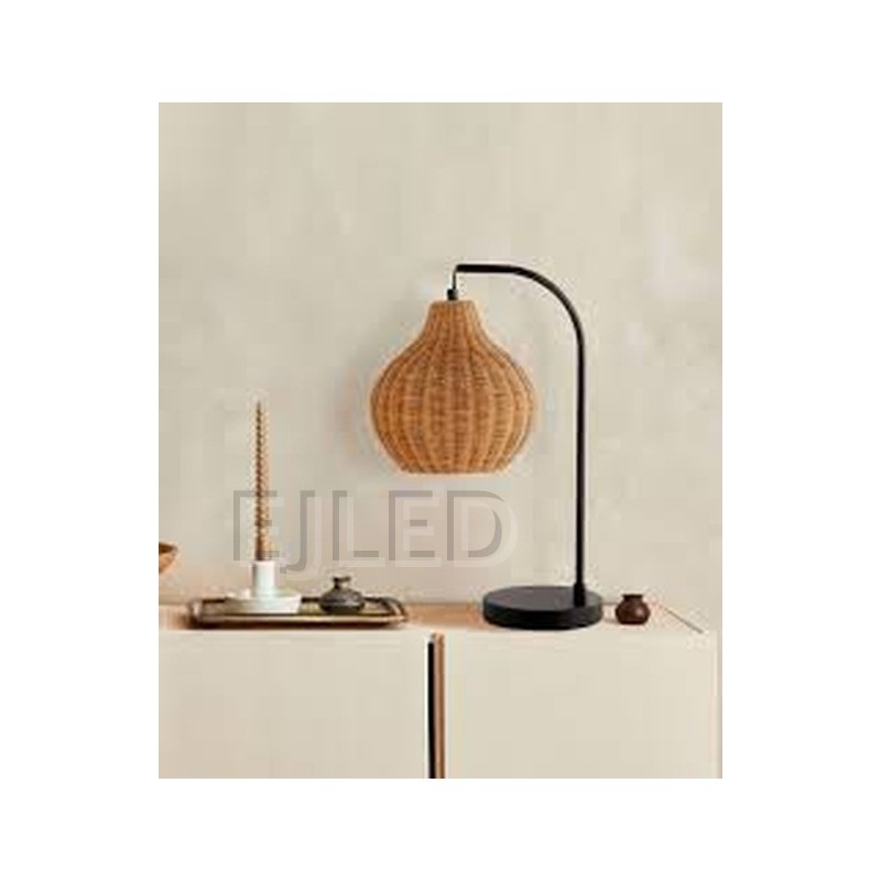This table lamp features a curved black metal arm holding a woven rattan shade with an open bottom, mounted on a flat round base. - view 2