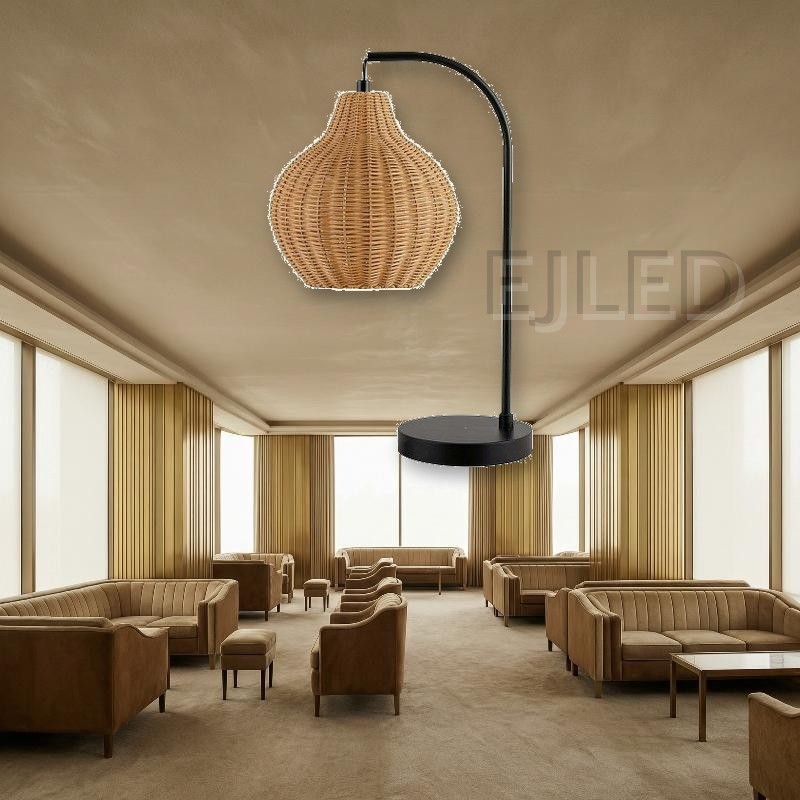 This table lamp features a curved black metal arm holding a woven rattan shade with an open bottom, mounted on a flat round base. - view 4