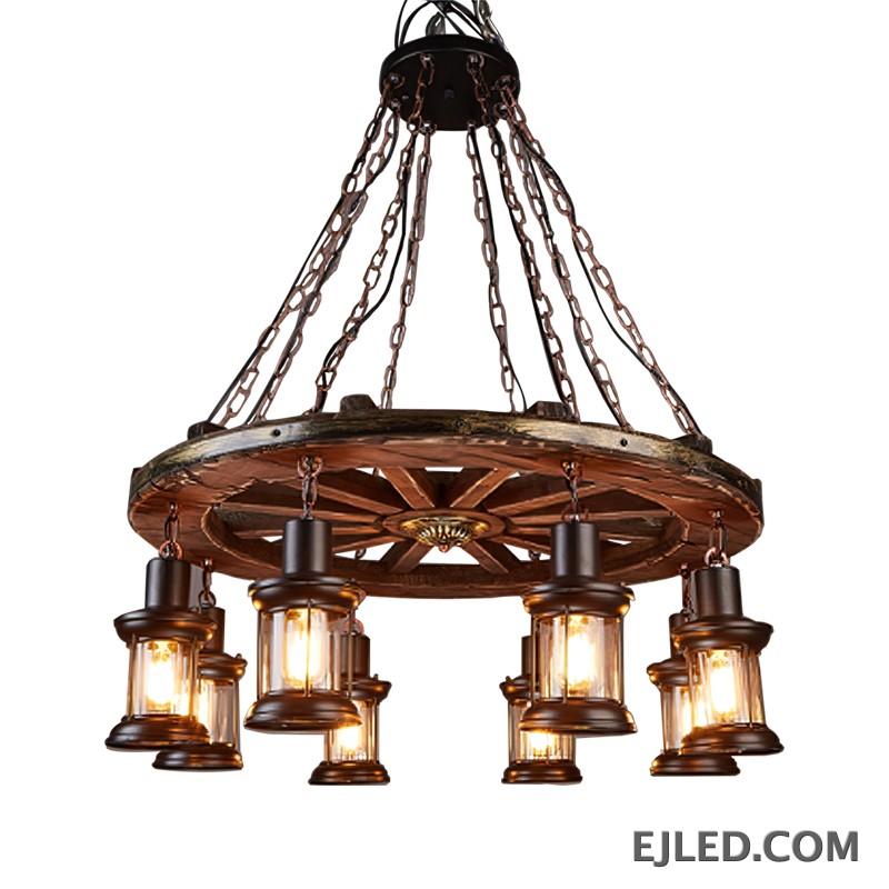 This fixture features a distressed wooden wagon wheel frame suspending eight lantern-style lights. It hangs from multiple chains, creating a rustic aesthetic suitable for various interior designs.