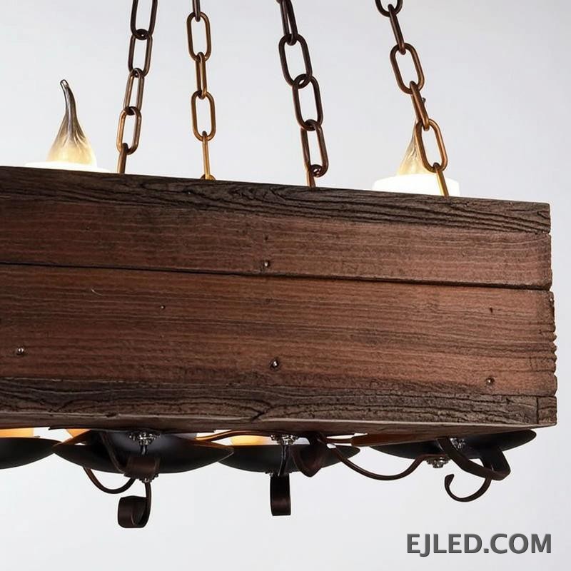 This pendant chandelier features a rectangular wooden beam body suspended by chains. Multiple candle-style lights are mounted on dark metal holders, offering a distinct rustic aesthetic suitable for various project designs. - view 6