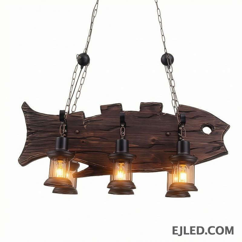 Esta lámpara colgante de techo de madera WD0013 presenta una distintiva forma de pez, con tres luces individuales tipo farol. Su acabado oscuro y rústico y su suspensión con cadenas crean una estética única para diversos interiores.