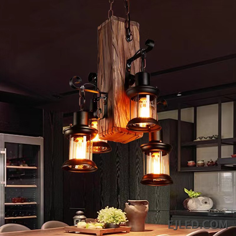 Esta lámpara colgante de madera WD0015 presenta una viga de madera envejecida que sostiene cuatro luces tipo farol. Las pantallas de vidrio transparente albergan bombillas visibles, ofreciendo un atractivo rústico para diversos proyectos de interior. - view 2
