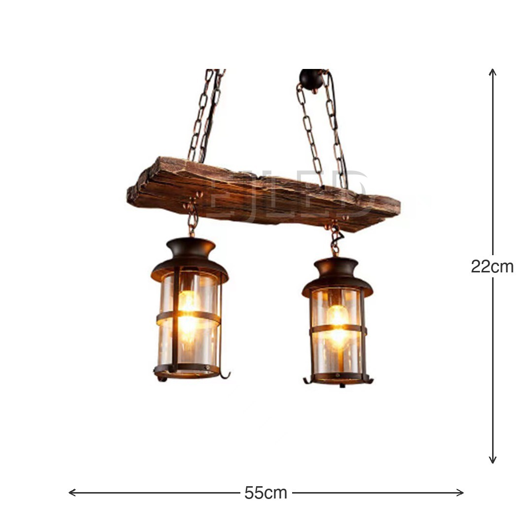 Esta lámpara presenta una viga de madera de aspecto rústico de la que cuelgan dos lámparas colgantes cilíndricas. Cada lámpara tiene una estructura de metal oscuro con paneles de vidrio transparente que emiten una luz cálida. Se cuelga mediante cadenas resistentes para un aspecto robusto. - view 4