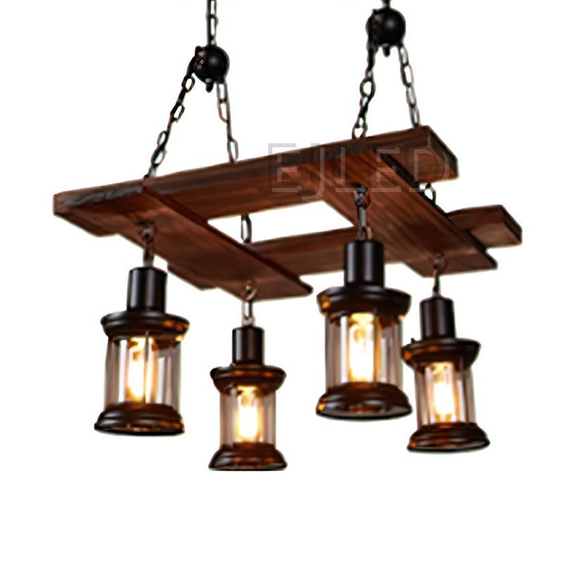 This wood chandelier features a rectangular wooden frame suspending four individual cylindrical lantern-style lamps. Each lamp has a dark metal top and bottom with a clear enclosed glass body, providing focused light.