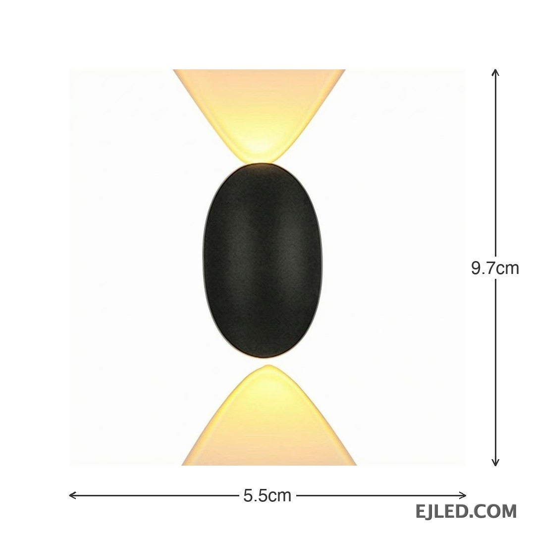 This black plastic wall light features a rounded rectangular front face and a diffused light output. It casts a soft, ambient glow upwards, downwards, and slightly forward, suitable for subtle accent illumination. - view 4