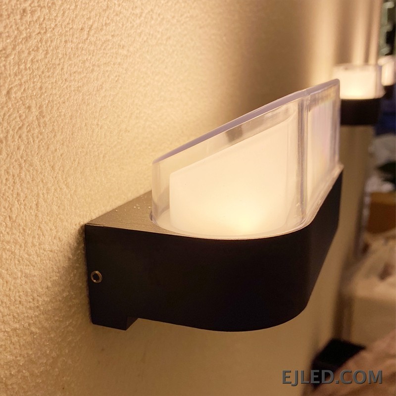 Esta lámpara de pared presenta un cuerpo rectangular de plástico con base negra y un difusor curvo de plástico transparente. Está diseñada para montaje en pared y proporciona iluminación cerrada. - view 3