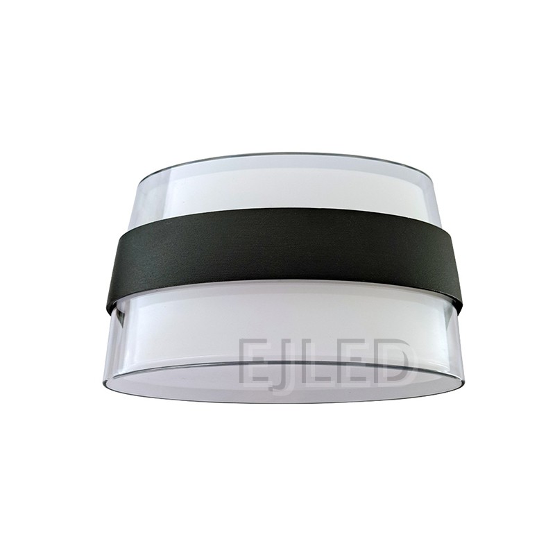 This wall light features a clear acrylic outer layer surrounding a white acrylic diffuser. A distinctive black band wraps around the middle, providing a modern and clean aesthetic for various interior settings.
