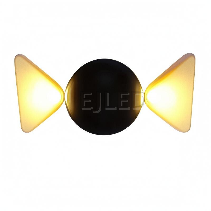 This wall light features a round black acrylic body flanked by two glowing triangular shades that project warm light outward on both sides.