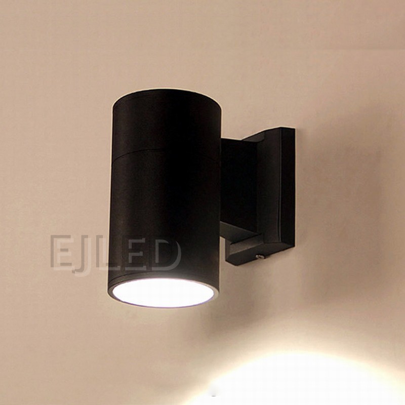 This black aluminum cylindrical wall light features a tubular body mounted on a matching rectangular wall bracket, directing illumination downward. - view 2