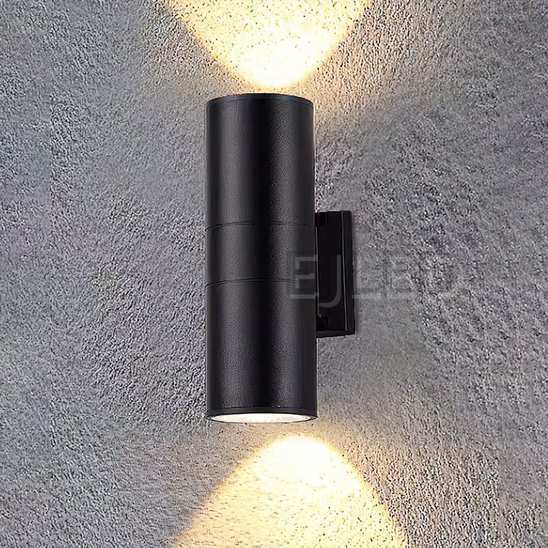 This black aluminum cylindrical wall light features a tubular body mounted on a matching rectangular wall bracket, directing illumination downward. - view 4